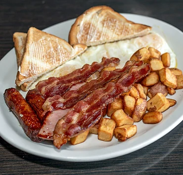 Breakfast plate with bacon, sausage, eggs, home fries and toast
