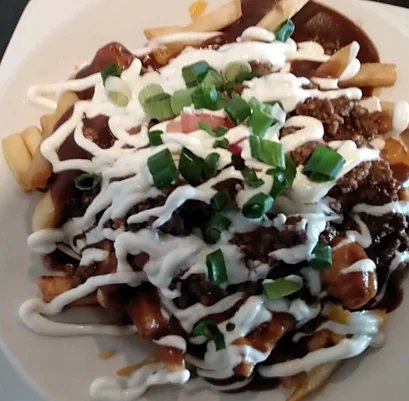 Mexican poutine with seasoned beef, sour cream and green onion