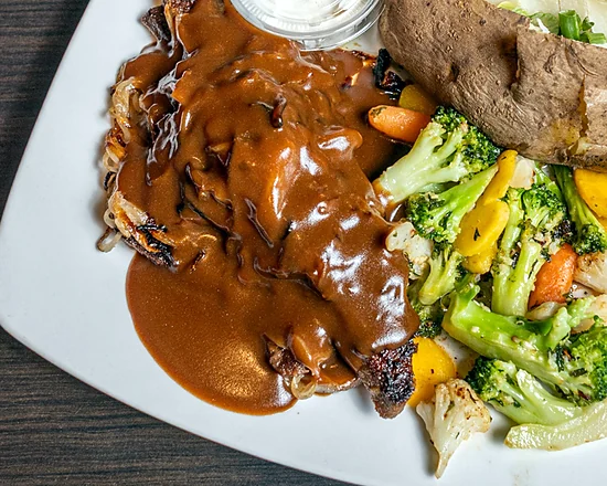 Liver and onions in gravy with a baked potato and mixed vegetables